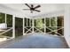 Inviting screened porch features a ceiling fan, gray flooring, and a blue area rug providing a peaceful outdoor retreat at 999 Bailey Rd, Woodstock, GA 30188