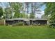 The backyard has green grass, mature trees, and a patio area with furniture at 2762 Whispering Pines Dr, Decatur, GA 30033