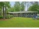 Charming home backyard featuring a well-maintained lawn, patio seating, and colorful flower boxes at 2762 Whispering Pines Dr, Decatur, GA 30033
