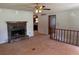 Open living room with a stone fireplace, ceiling fan, and access to other rooms at 285 Woodland St, Dallas, GA 30157