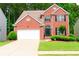 Charming brick home with a well-manicured lawn, an attached garage, and mature trees in a desirable neighborhood at 318 Ivy Manor Nw Dr, Marietta, GA 30064
