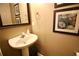 A pedestal sink in a powder room, accented by artwork and a decorative mirror at 318 Ivy Manor Nw Dr, Marietta, GA 30064
