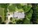 Aerial view of home with a gray roof, several parked cars, a trampoline, and lush surrounding greenery at 78 N Pomona Rd, Hampton, GA 30228