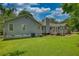 Picturesque backyard featuring a lush lawn, wood deck, and mature trees at 78 N Pomona Rd, Hampton, GA 30228