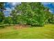 Wide backyard with a fenced area, providing shade and room to roam under a large tree at 78 N Pomona Rd, Hampton, GA 30228