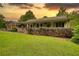 Inviting single-story home featuring a cozy front porch, manicured lawn, and lush, mature landscaping at 78 N Pomona Rd, Hampton, GA 30228