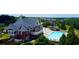 Aerial view of community clubhouse with a pool, manicured landscaping, and outdoor seating area at 1420 Baygreen Rd, Suwanee, GA 30024