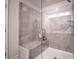 Modern bathroom shower with gray tile, glass door, bench, and built in shelving at 1420 Baygreen Rd, Suwanee, GA 30024