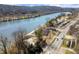Scenic aerial view of property along the river, featuring mature trees, parking, and boat storage at 220 Riverview Trl, Roswell, GA 30075