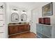 Spacious bathroom featuring double sinks, wood cabinets, hardwood floors, and stylish decor at 220 Riverview Trl, Roswell, GA 30075