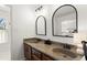 Bright bathroom featuring a double vanity with stone countertops, arched mirrors, and modern fixtures at 220 Riverview Trl, Roswell, GA 30075