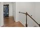 Well-lit hallway with hardwood floors, a white spindle staircase, and a black bookshelf at 220 Riverview Trl, Roswell, GA 30075