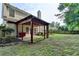 Exterior view of back of home with a covered patio and manicured landscaping at 2477 Lakebrooke Dr, Marietta, GA 30066