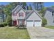 Charming two-story home with a well-manicured lawn, red door, red shutters, and attached two-car garage at 2477 Lakebrooke Dr, Marietta, GA 30066