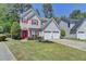 Charming two-story home with a well-manicured lawn, red door, red shutters, and attached two-car garage at 2477 Lakebrooke Dr, Marietta, GA 30066
