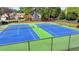 Overhead view of fenced in tennis courts, painted green and blue at 2477 Lakebrooke Dr, Marietta, GA 30066
