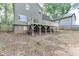 View of the home's backyard, featuring a deck, lush greenery, and mature trees providing ample shade at 440 S Alexander St, Buford, GA 30518