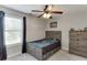 Inviting bedroom featuring a rustic-style dresser, natural light, and ceiling fan, enhancing comfort at 440 S Alexander St, Buford, GA 30518