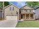 Charming two-story home with a covered front porch, a two-car garage, and a well-manicured lawn at 440 S Alexander St, Buford, GA 30518