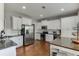 This kitchen features white cabinets, stainless appliances, and a dining area with stools at 440 S Alexander St, Buford, GA 30518