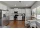 This kitchen features white cabinets, stainless appliances, and a dining area with stools at 440 S Alexander St, Buford, GA 30518