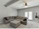 Spacious living room boasts a sectional sofa, ceiling fan, and access to the outdoors at 440 S Alexander St, Buford, GA 30518