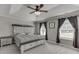 Relaxing main bedroom features a ceiling fan, tray ceilings, and a decorative headboard at 440 S Alexander St, Buford, GA 30518