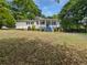 Inviting single-story home featuring a blue-accented porch, complemented by mature trees and front yard landscaping at 1886 Akron Se Dr, Atlanta, GA 30315