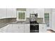 Bright kitchen with white cabinets, stainless steel appliances, granite countertops, and a window at 1886 Akron Se Dr, Atlanta, GA 30315