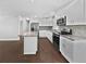 Open-concept kitchen with white cabinets, stainless steel appliances, island, and hardwood floors at 1886 Akron Se Dr, Atlanta, GA 30315