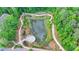Aerial view of community pond surrounded by lush greenery and walking trails with an amphitheater at 221 Thompson St, Alpharetta, GA 30009