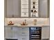 A bar with glass shelving and a wine cooler offers luxury with a modern design at 221 Thompson St, Alpharetta, GA 30009