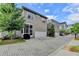 View of new townhomes showing brick paved driveways and rear entry garages, ideal for convenient parking at 221 Thompson St, Alpharetta, GA 30009