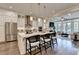 Modern white kitchen seamlessly connects to the living area, featuring a large island with seating and stainless appliances at 221 Thompson St, Alpharetta, GA 30009