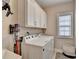 Well-lit laundry room featuring a side-by-side washer and dryer and built-in cabinets for storage at 221 Thompson St, Alpharetta, GA 30009