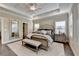 Spacious main bedroom featuring a tray ceiling, plush carpeting, a walk-in closet, and abundant natural light at 221 Thompson St, Alpharetta, GA 30009