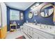 Bathroom with double sinks, white cabinets, and navy walls at 4442 Mclain Cir, Acworth, GA 30101
