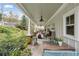 Inviting covered front porch with tiled floors, comfortable seating and backyard views at 4442 Mclain Cir, Acworth, GA 30101