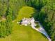 Aerial view of a grand home surrounded by lush trees and a well-manicured lawn at 692 Brooks Woolsey Rd, Brooks, GA 30205