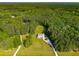 Expansive aerial view of a charming home nestled on a lush green lot surrounded by dense, mature trees at 692 Brooks Woolsey Rd, Brooks, GA 30205