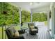Relax on the covered back porch with comfortable seating and serene views of the surrounding trees at 692 Brooks Woolsey Rd, Brooks, GA 30205