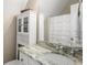 Bright bathroom with a marble countertop, white cabinets, and decorative mirror at 692 Brooks Woolsey Rd, Brooks, GA 30205