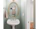Charming bathroom features a pedestal sink, decorative mirror, and soft, muted color scheme at 692 Brooks Woolsey Rd, Brooks, GA 30205