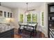 Sunlit dining area features large windows with backyard views and a black wood dining set at 692 Brooks Woolsey Rd, Brooks, GA 30205