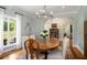Formal dining room featuring wood table, hardwood floors, elegant chandelier, and natural light at 692 Brooks Woolsey Rd, Brooks, GA 30205