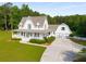 Beautiful white farmhouse with a wide porch, attached garage, and spacious driveway at 692 Brooks Woolsey Rd, Brooks, GA 30205