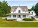 Charming two-story white home with a welcoming front porch and well-manicured landscaping at 692 Brooks Woolsey Rd, Brooks, GA 30205