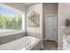 Relaxing soaking tub with backyard view in the main bathroom at 692 Brooks Woolsey Rd, Brooks, GA 30205