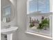 Bright powder room features pedestal sink and view to the exterior through blinds at 893 Society Sw Cir, Atlanta, GA 30331