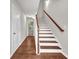 Hallway view with a staircase featuring wood handrail and treads and white risers at 893 Society Sw Cir, Atlanta, GA 30331